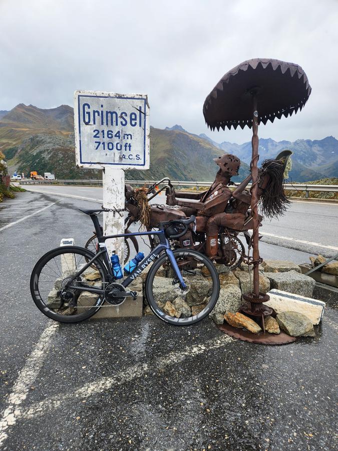 A road bike leaning on the Grimsel Pass summit sign