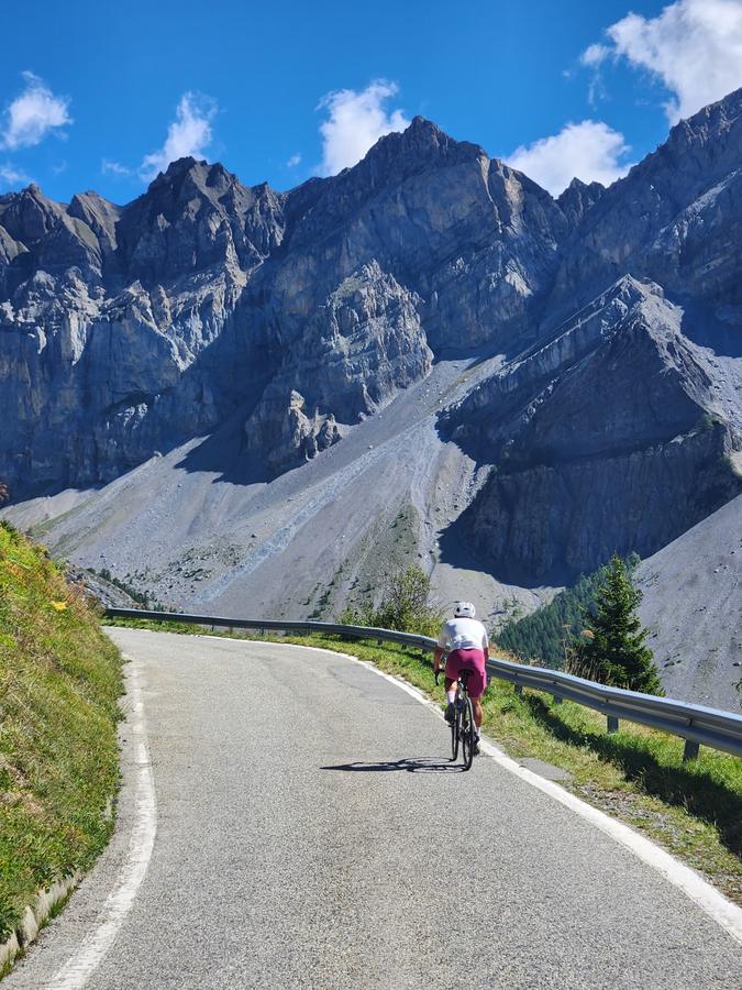 A rider on the upper Sanetsch road below steep grey peaks