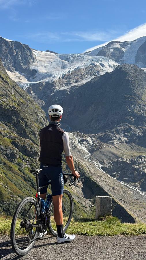 A rider standing with the bike, looking up at the Steingletscher