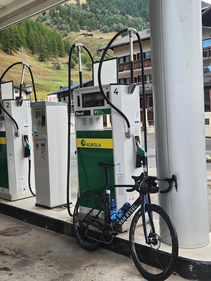 A road bike parked at the petrol pumps in Ulrichen